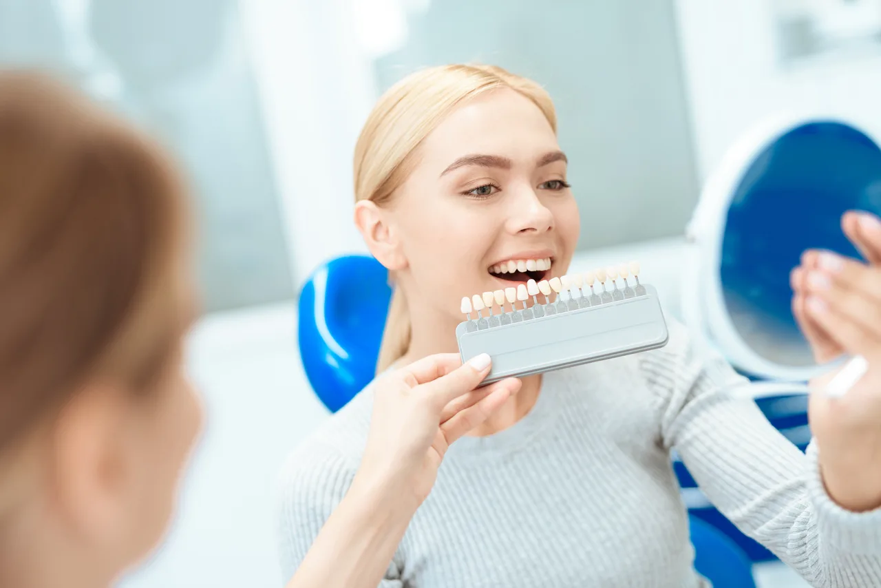 Patient reviewing tooth shades with a dentist in the dental office